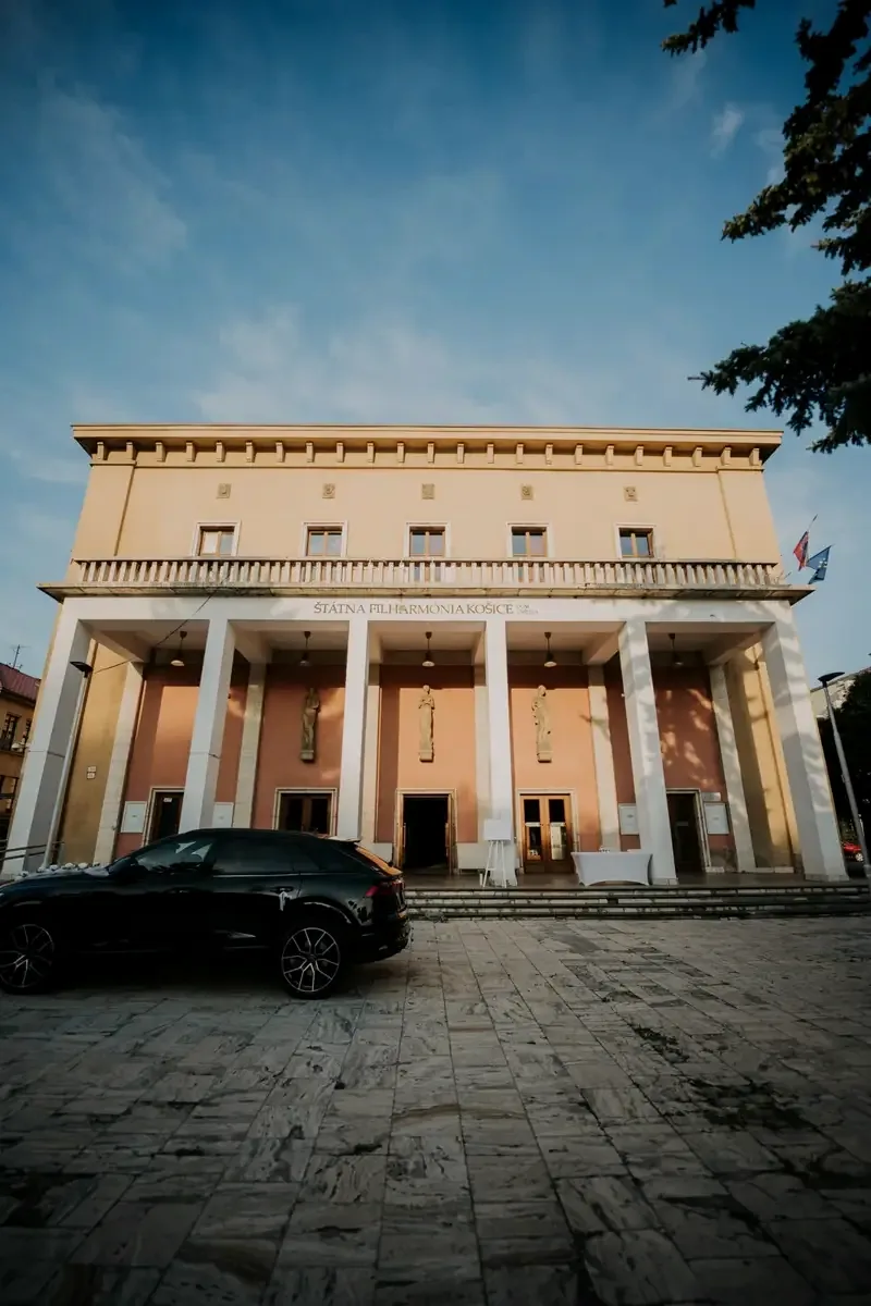 Dom umenia pri západe slnka s autom novomanželov